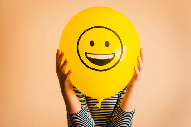 Person holding a yellow balloon with a happy face, symbolizing improved customer satisfaction.