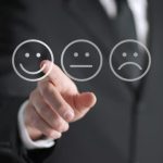 Businessperson in suit selecting a happy face icon, emphasizing customer satisfaction improvement.